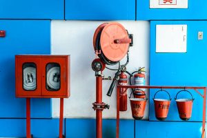 Wall Hanging Fire Extinguisher, Fire Safety and Emergency Equipment install in Red Blue Box wall mount arctural fire extinguisher glass cabinet in a Industrial building.