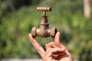 antique tap used to control the flow the water made of brass held in hand